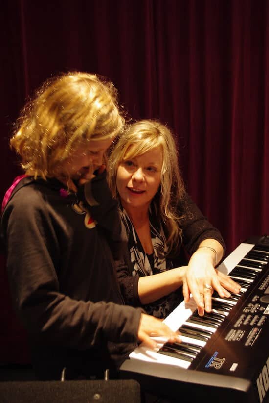 Female Piano Teacher Teaching a student